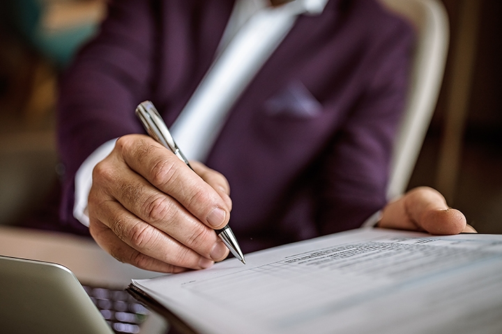 senior businessman signing document