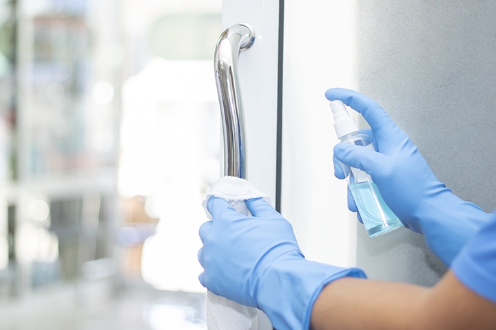 spray cleaning door handle with sanitizer