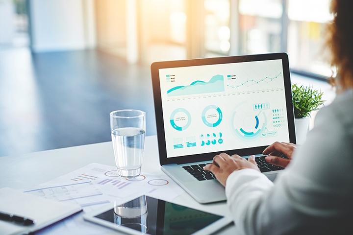 woman working on laptop with graphs and charts