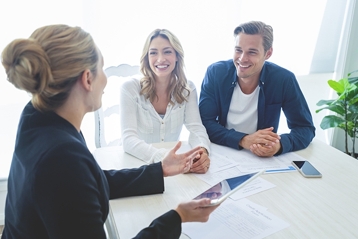 insurance agent with couple looking through documents