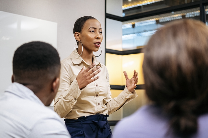 Businesswoman empowering employees and speaking passionately during a meeting, ambition, aspiration