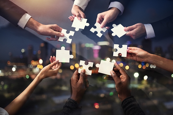 Hommes d'affaires travaillant ensemble pour construire un puzzle.