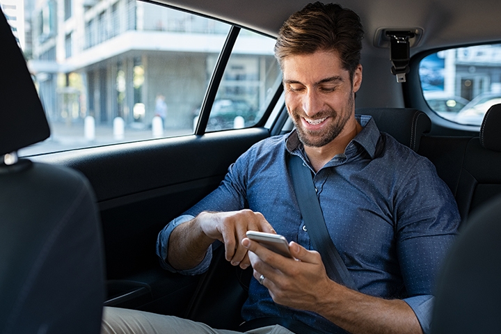 homme qui utilise son portable dans une voiture