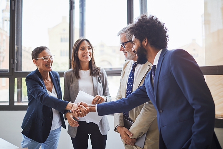 Group of working professionals, customers smiling, shaking hands, good experience