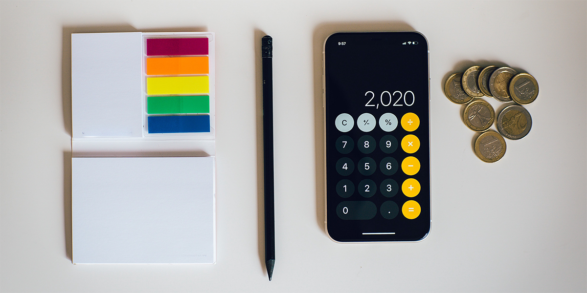A notepad, pencil and an iphone on a desk