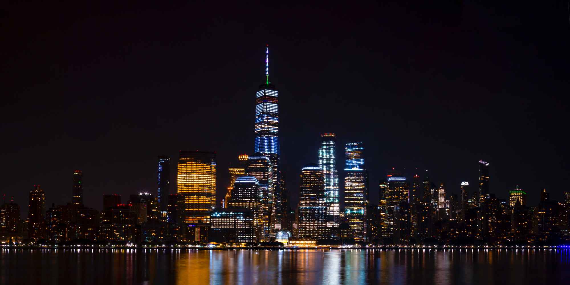 Picture of a skyline at night with lights reflecting in a river