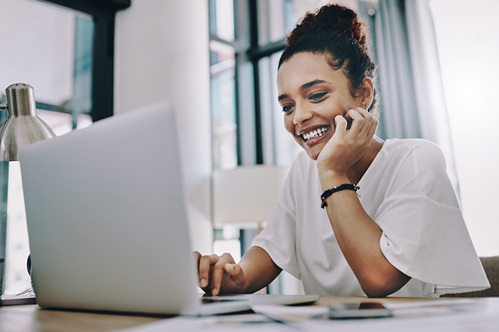 woman sitting at her computer smiling