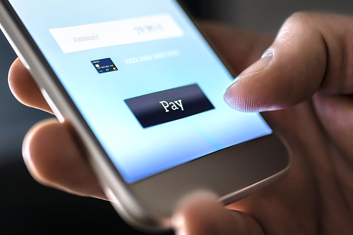 Thumb using a banking wallet app to complete transaction