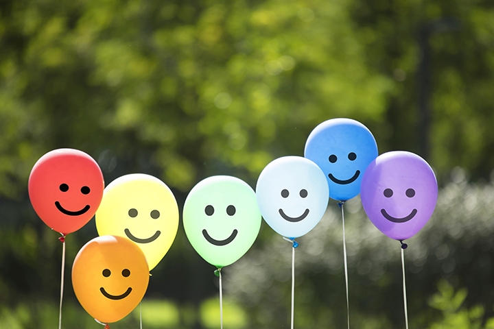 group of balloons with smiles on the front, multi-colored