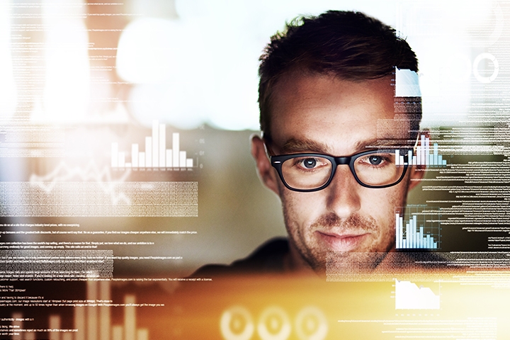 man looking at his computer with graphs and data analytics in the background