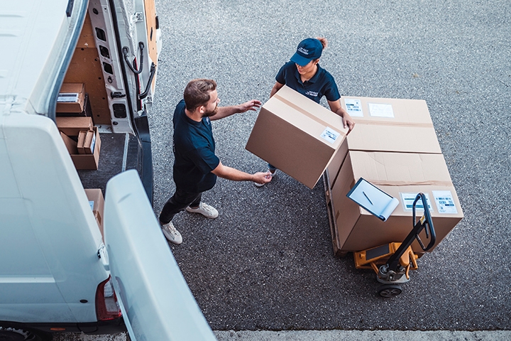 Delivery workers using a Hydraulic Hand Pallet Truck to load a delivery van.