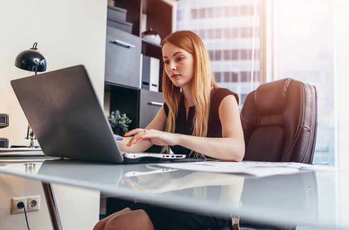 a blond woman working at desk