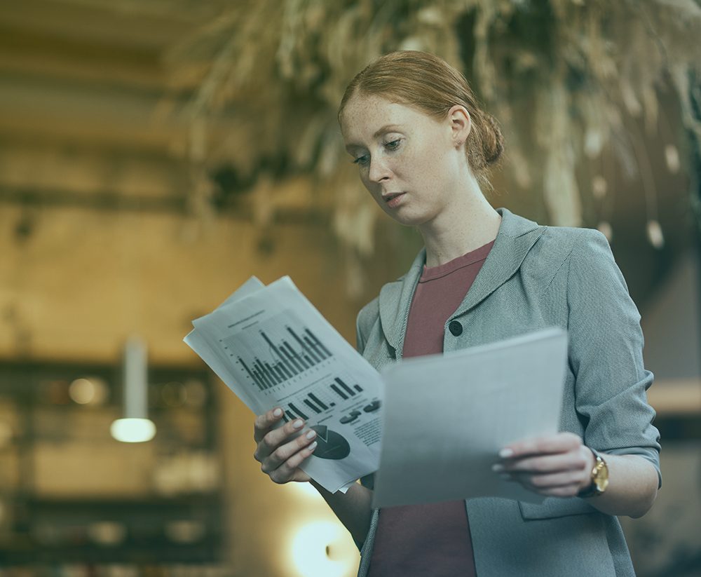 Businesswoman reading newspaper in hotel lobby