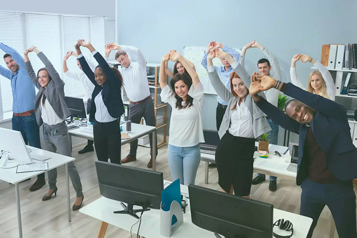 Business people stretching in unison in office