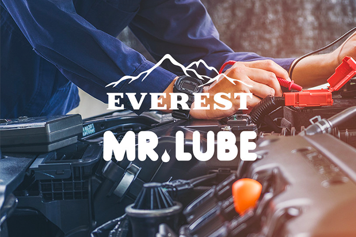 Photo of a mechanic working on a car with Everest and Mr. Lube logos overtop