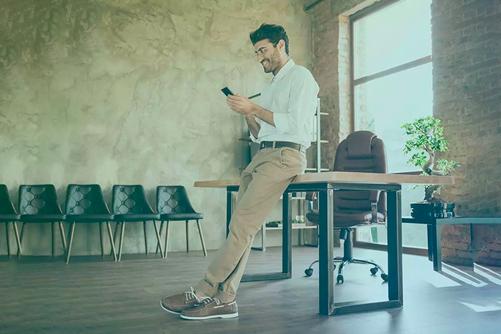 Man standing by desk in empty office