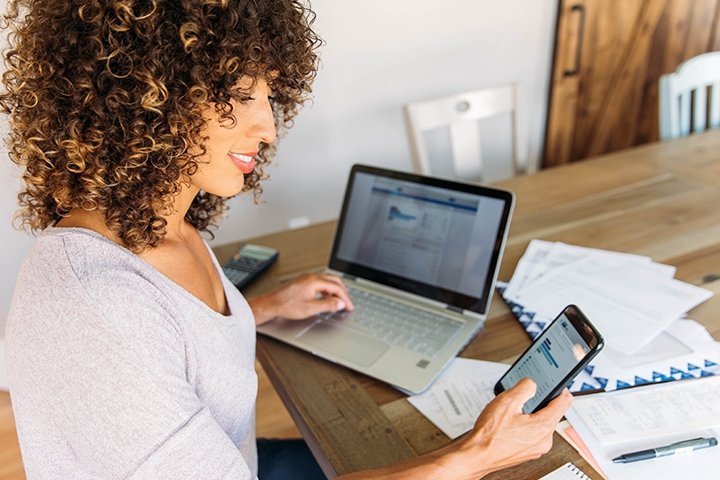 woman sitting with phone and computer