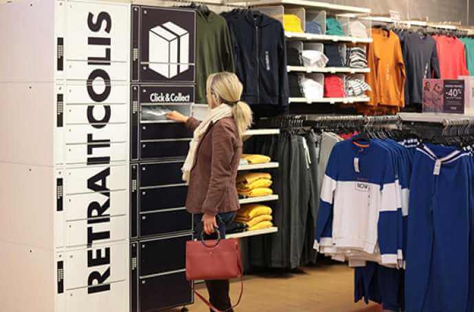 a blond woman collecting a parcel from a parcel locker located in a clothes shop a blond woman collecting a parcel from a parcel locker located in a clothes shop