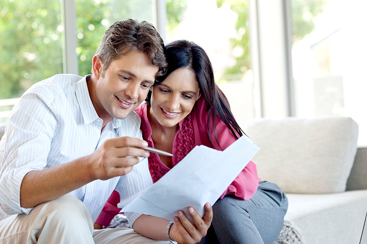 Happy couple reading a letter with offer