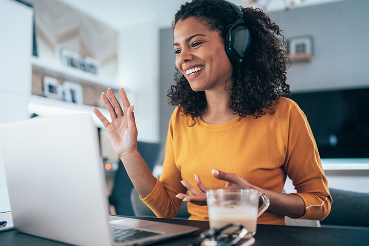 female wearing headphones talks to customer over videocall