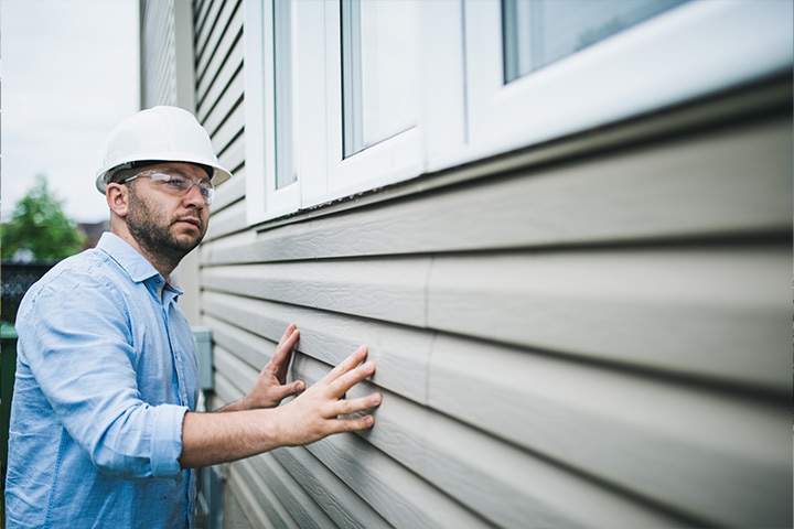 home builder inspecting siding