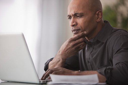 man thinking while viewing monitor