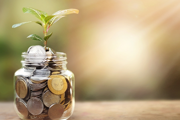 Jar of coins with a growing plant, representing AP automation savings, cost control, and improved finance efficiency.