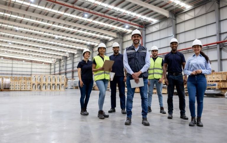 team of people standing with safety helmuts on