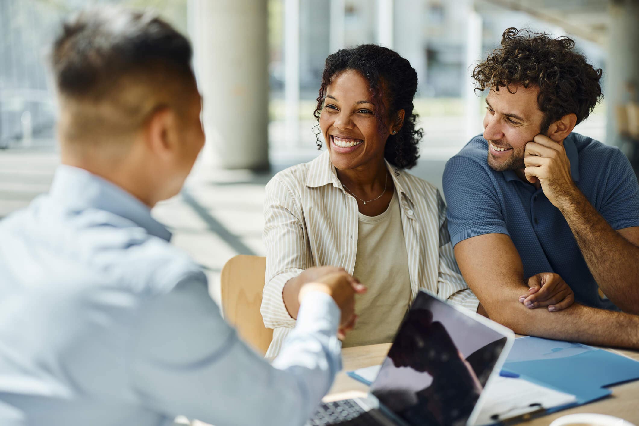 People smiling and shaking hands in a bank