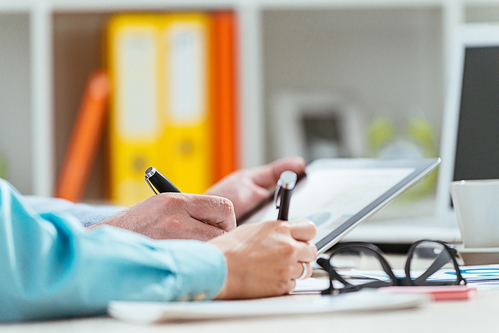 people writing on a tablet with electronic pens