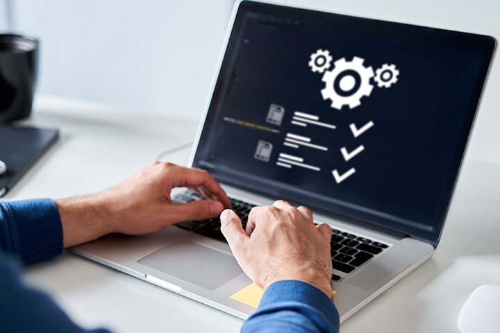 Man typing on laptop that displays content elements with checkmarks featured alongside, representing AI-assisted content authoring