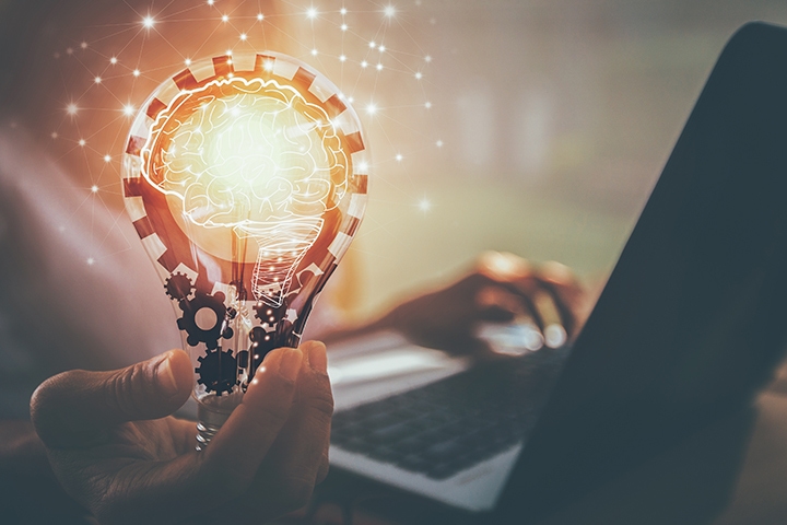 Woman holding a glowing light bulb representing innovative thinking