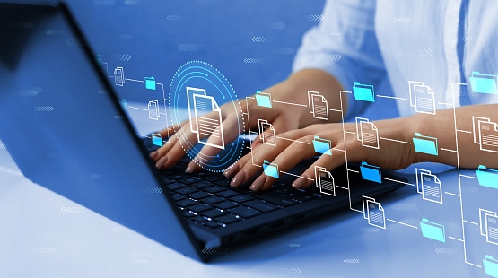 Person typing on a laptop with floating digital document and accessibility icons representing PDF accessibility testing, document structure, and compliance verification.