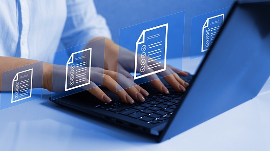 Person typing on a laptop with floating digital document icons, representing accessible document creation and digital workflow management.