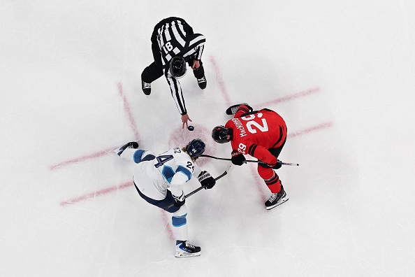 Two hockey players face off on the ice