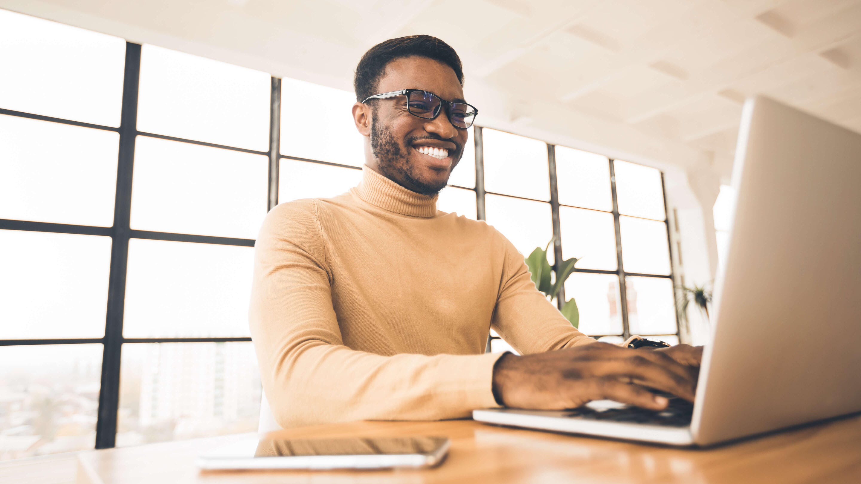 businessman typing on laptop smiling