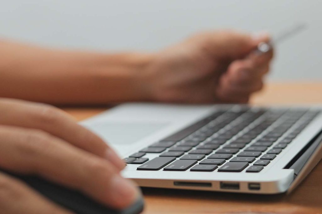 person using laptop for electronic payments